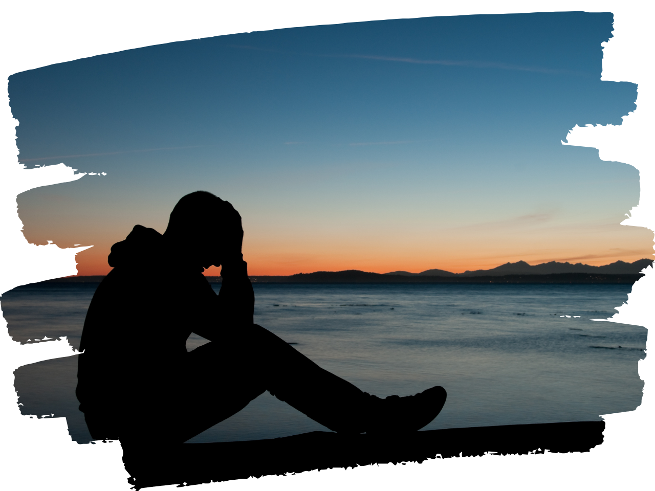 Person sitting along on a mountain with clouds in the distance, holding their head in their hands in frustration