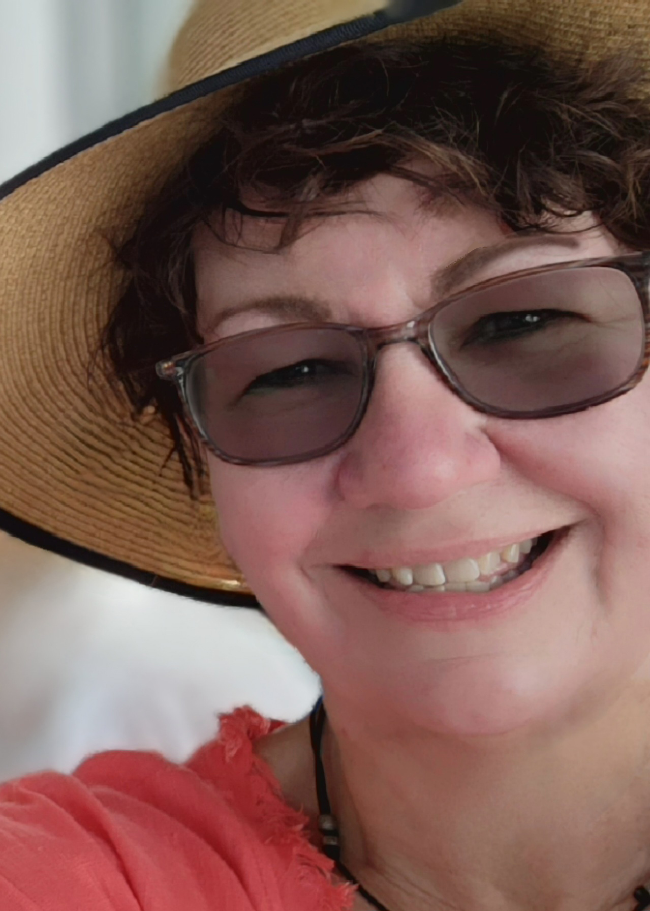 Close up profile picture of Lisa Tussey wearing a straw hat and darkened glasses