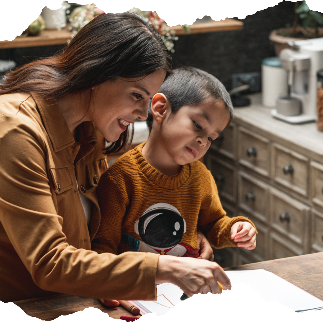 Mother helping child with writing at the kitchen counter