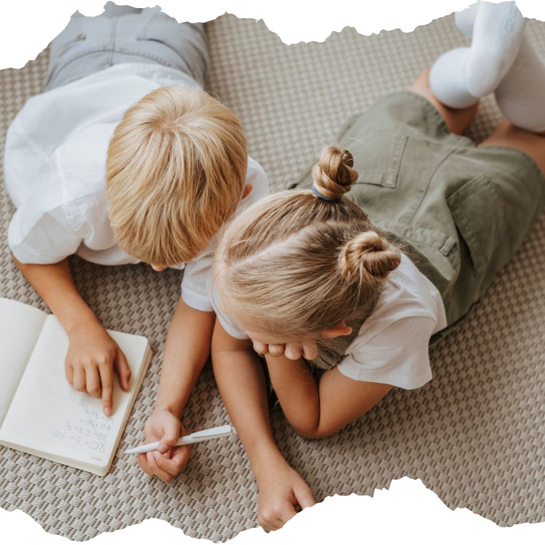 Two small children writing on the floor