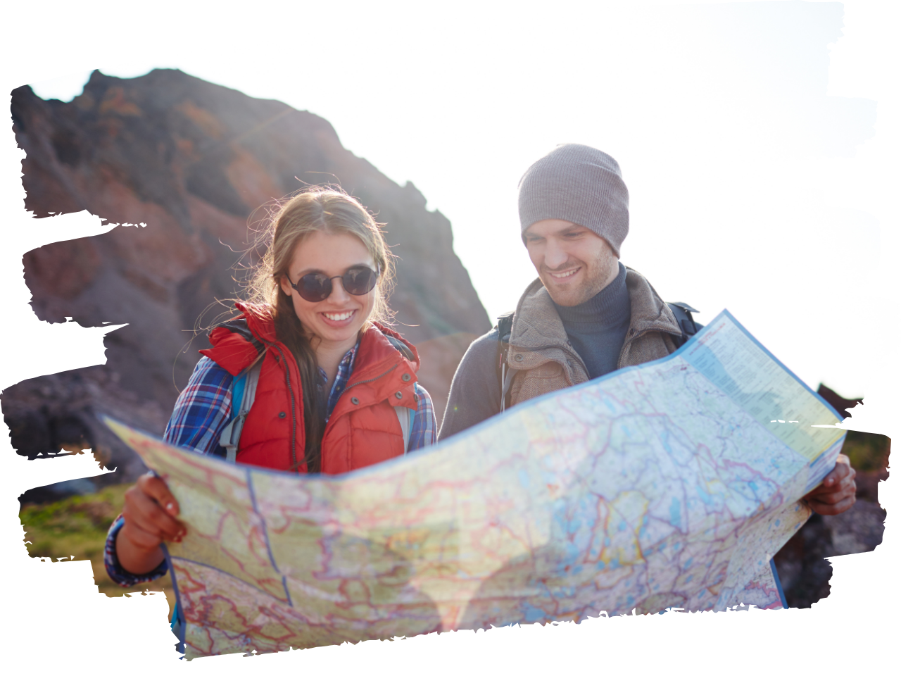 Two hikers looking at a map together with a rocky mountain in the background